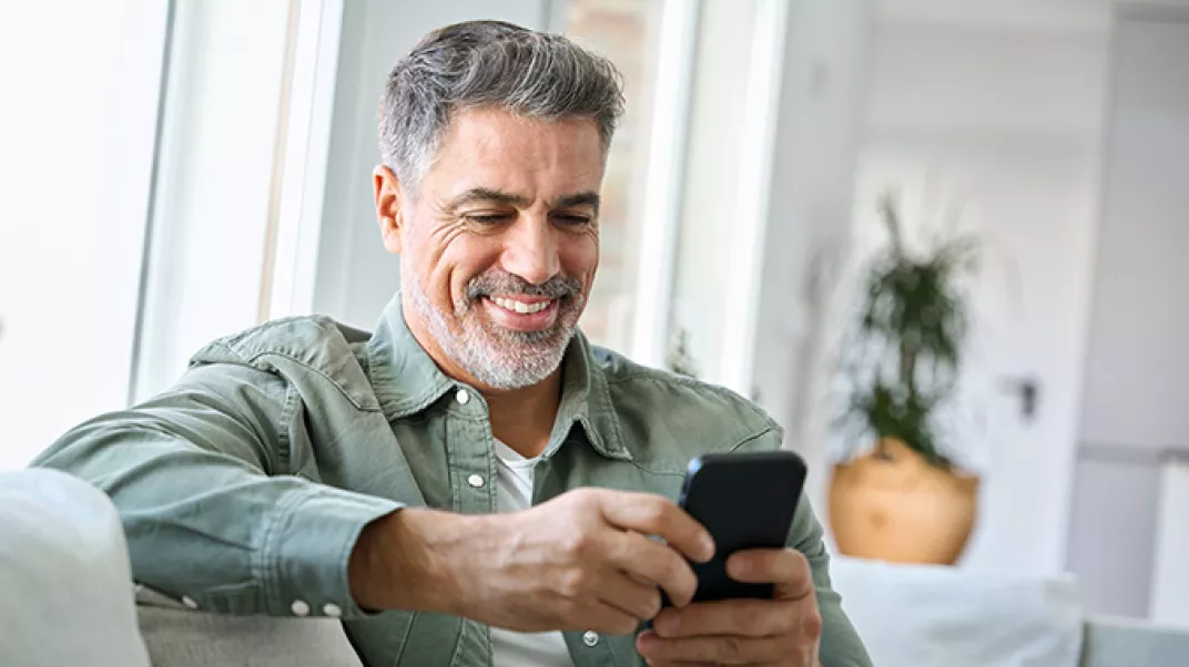 middle aged man smiling looking at phone